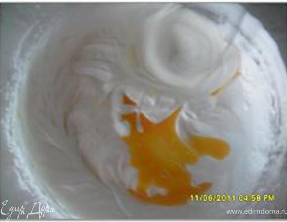 Переключить миксер на более низкую скорость и, не прерывая взбивания, ввести желтки. 