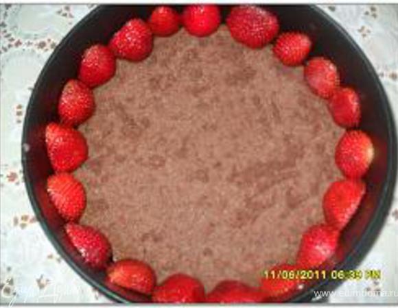 Нижний пласт коржа положить на круглое блюдо и окружить его разъемной формой, выложить клубничный крем, а затем творожный и разровнять. Сверху положить следующий пласт. 