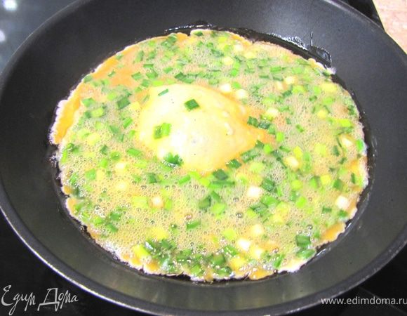 Разогрейте растительное масло на сковороде на среднем огне.
Когда масло нагреется вылейте смесь яиц и лука в сковороду. Яичница сразу должна скворчать.