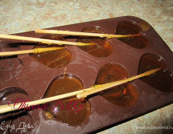 Разлить карамель в формочки, воткнуть деревянные палочки. Если вы используете силиконовые формочки, то нужно немножко подождать когда карамель застынет и с наклоном положить в низ палочки.