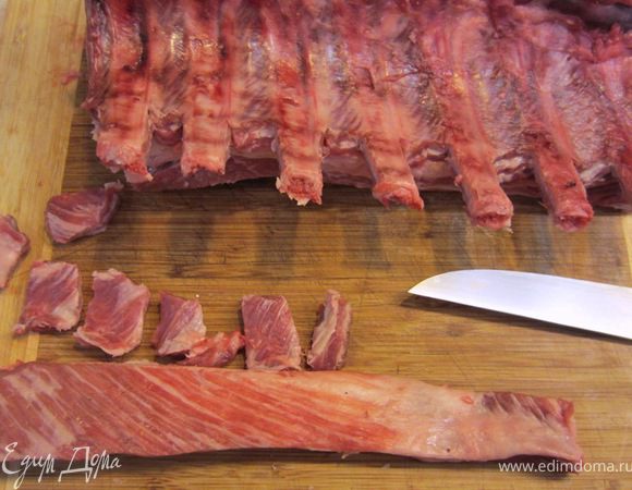 Переверните мясо ребрами наверх. Срежьте мясо между ребрами, чтобы оголились концы. Маленьким ножом соскоблите остатки мяса с ребер, чтобы они аккуратно смотрелись. *** Сделайте тоже самое со второй корейкой. ***