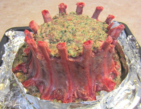 Из фольги сделайте длинную полосу длиной в три с половиной диаметра получившейся "короны". Сложите полосу вдоль несколько раз, чтобы получилась полоса шириной около 5 сантиметров. Оберните "корону" по низу этой полосой. Край полосы загните наверх и заверните внутрь. Таким образом полоса будет держаться. Концы ребер заверните в фольгу, чтобы они не пригорели в процессе длительного запекания.