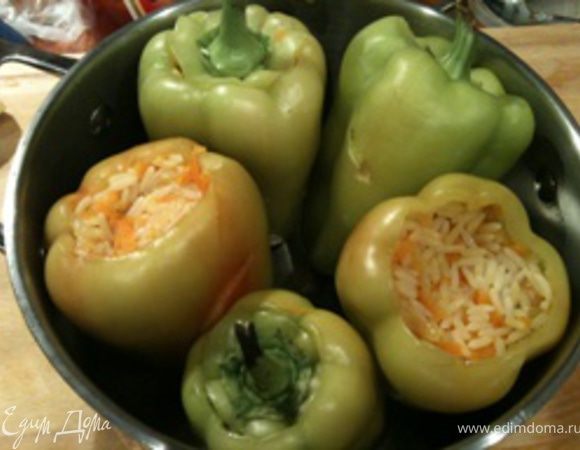 Отваренный и остывший рис смешать с тертой морковью. Этим фаршем плотно и аккуратно наполнить перец, и поместить его в кастрюлю. Перец закрыть "крышечками".