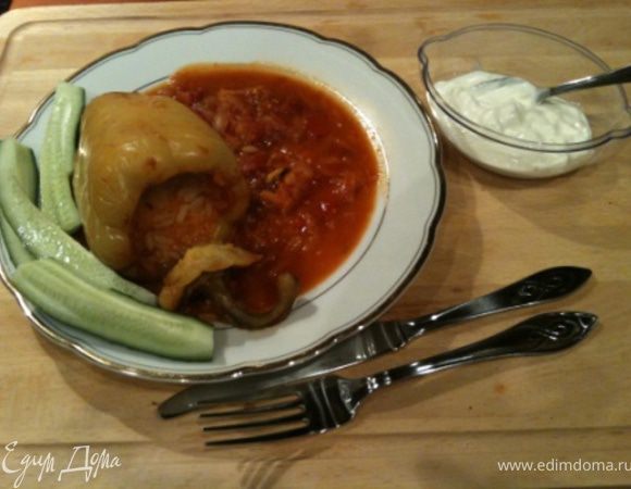 Готовый фаршированный перец подавать горячим в порционных тарелках с добавлением сметаны.
Приятного аппетита!