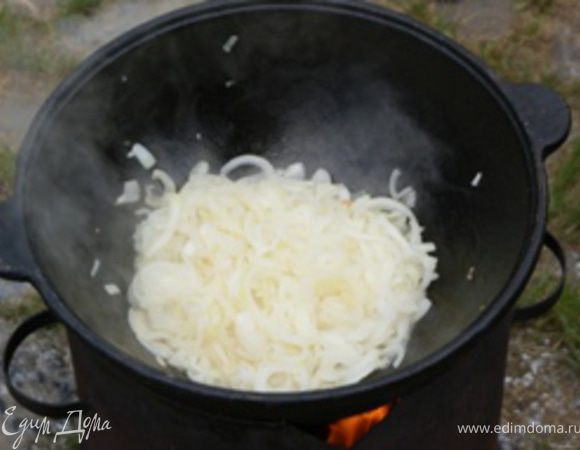 Казан поставить огонь, налить растительное масло, положить лук для тушения. Немного посолить. Огонь средний. Тушить 15-20 минут до золотистого цвета периодически помешивая.
ВАЖНО: Далее все ингридиенты закладываются постепенно, по готовности предыдущего шага. Казан накрывается крышкой только в Шаге 7.