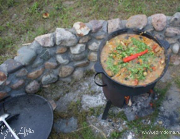 Проверить достаточность соли и специй в блюде (по вкусу. Порубить свежую зелень, головки чеснока очистить от верхнего слоя шелухи(второй слой шелухи должен остаться; чеснок на зубчики не разделять), и все добавить в казан. Также в казан сверху положить один острый помытый чили перец.(ВАЖНО: перец кладется аккуратно и целиком, стенки перца со всех сторон должны быть не поврежденными! с перцем блюдо не мешать!)Теперь можно казан закрыть крышкой, огонь убавить до очень умеренного и оставить тушить не мешая минут 40-60 в зависимости от того, насколько мягкое мясо вы хотите получить в итоге. В процессе готовки необходимо проверять кипит ли содержимое казана (не поднимая крышку, а прислушиваясь к звукам внутри казана). По истечении времени убрать огонь, снять крышку казана, аккуратно (чтобы не повредить) вынуть чили-перец, перемешать все ингридиенты, снова накрыть крышкой и оставить на 20-30 минут настаиваться. Затем можно подавать к столу и наслаждаться непередаваемым вкусом и ароматом.  Приятного аппетита!
