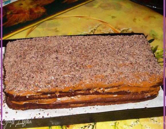 Пропитанные и поостывшие коржи смазываем кремом.
Собираем в тортик.

Ставим на ночь в холодильник для пропитки.
