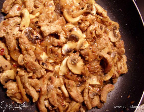 Шампиньоны промыть, обсушить, порезать крупными пластинками и добавить к мясу. Обжариваем 5 минут, затем солим и добавляем вино. Тушим на среднем огне, пока вино не впитается. 