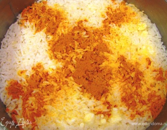 Сверху выложите остальной рис и полейте оставшимся маслом.
Посыпьте сверху часть риса куркумой. Тушите на минимальном огне в течение часа. Лично я ставлю кастрюлю прямо на дно в духовке при температуре 180 градусов. 