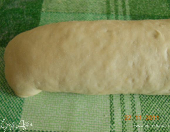 делаем рулет:
берем немного теста и раскатываем в тонкий пласт, и выкладываем на наш пласт капусту и распределяем по всему пласту, и скатываем тесто с начинкой в рулет