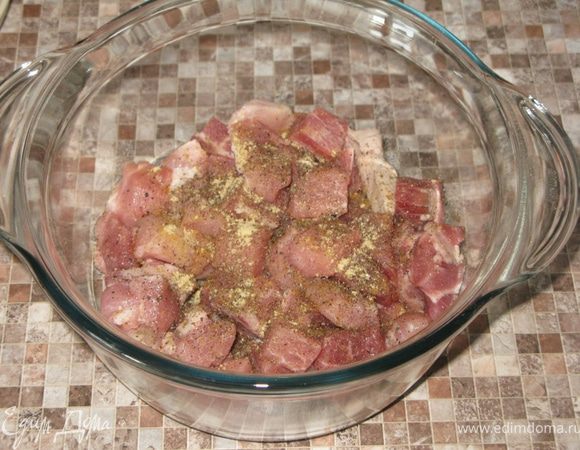Свинину режем на кусочки и выкладываем в стеклянную форму.  Солим, перчим, посыпаем молотым имбирём