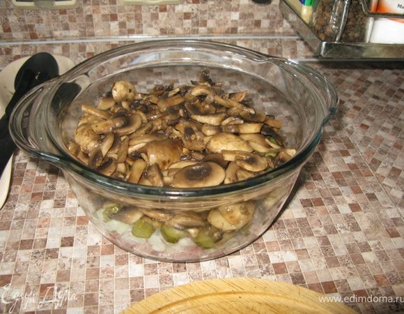 Далее кладём слой обжаренных на оливковом масле шампиньонов