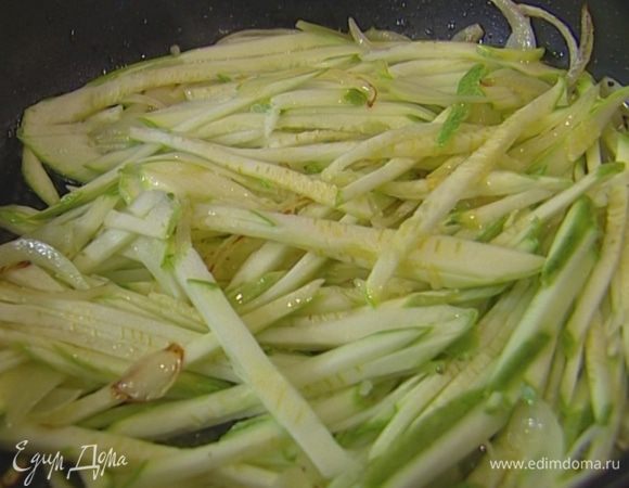 Цукини нарезать длинной тонкой соломкой, выложить к луку и тушить все вместе пару минут. 