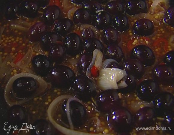 Приготовить соус Мостарда: шалот нарезать тонкими кольцами, перец чили без семян мелко порубить и слегка обжарить на разогретом в сковороде оливковом масле. Добавить виноград, горчицу, всыпать сахар, затем влить уксус и дать ему выпариться. Соус немного уварить.