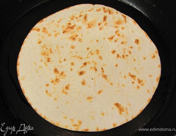 Разогрейте на сковороде без масла тортильи с двух сторон, чтобы они стали слегка золотистыми. Достаньте их из сковороды.