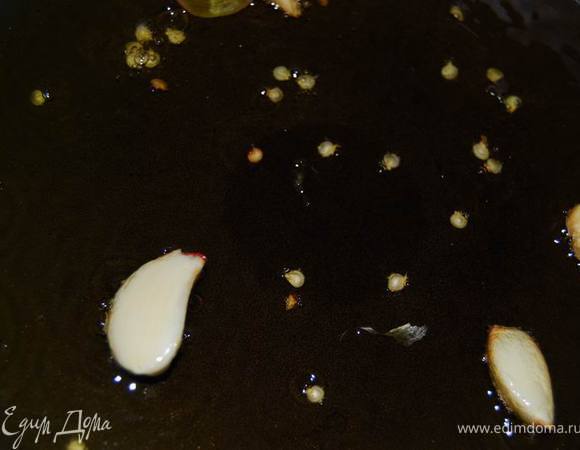 В большом количестве оливкового масло обжарить чеснок целыми зубчиками (3-4), добавить зерна горького перца.