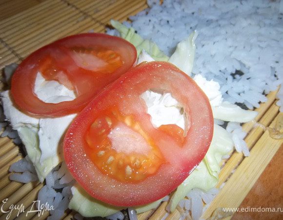 Поверх капусты выложить сыр «Филадельфия» (или любой другой сливочный сыр) и нарезанный помидор.