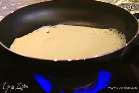 Разогреть сковороду для блинов, смазать ее оливковым маслом и выпекать тонкие блины.