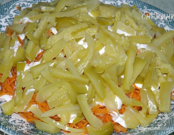 Огурчики режем соломкой и укладываем поверх моркови. Смазываем майонезом.