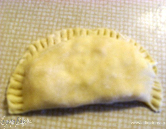 На одну половинку лепёшки выложить 3 ч.л. начинки, накрыть второй половинкой и слепить их вместе. Для прочности, что бы не вытекал расплавленный сыр, пройти по краю зубцами вилки плашмя. 