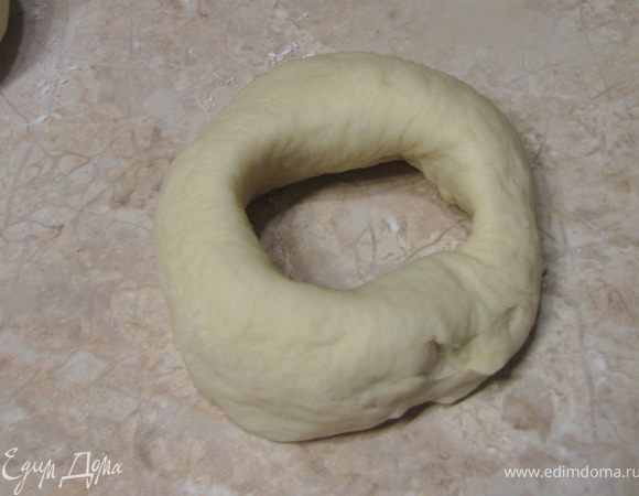 Проткните шарик пальцем посередине.
Надев шарик на палец, покрутите тестом, чтобы отверстие увеличилось до 5 сантиметров. Ровно сразу не получится, ну и ладно.