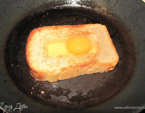 Возьмите небольшую сковороду с антипригарным покрытием. Налейте масло. Дайте нагреться.
Положите хлеб, пару минут обжарьте на одной стороне, чтобы хлеб несколько поджарился.
Переверните хлеб и сразу залейте яйца в отверстие. Разбивайте яйца аккуратно, чтобы желток не растекся (как для глазуньи).
Сделайте огонь ниже среднего и обжаривайте пару минут. Посолите и поперчите яйца. У меня поместилось одно яйцо. Возможно у вас поместится два. Главное, чтобы все отверстие заполнилось.