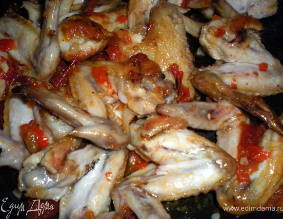 Обжаренные крылышки выложить в готовую заправку,перемешать и прогреть на слабом огне пару минут.