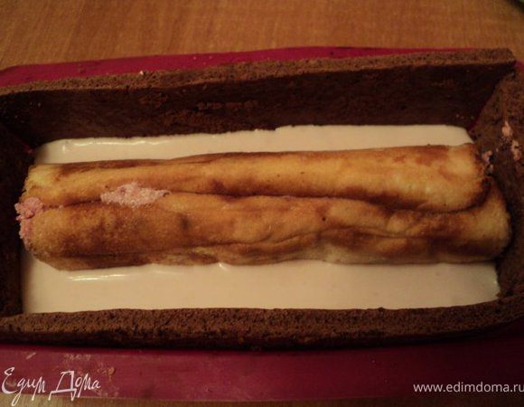 В подготовленную форму выложить половину белого крема,
уложить по середине рулет из белого цвета, слегка притопив его в креме.
