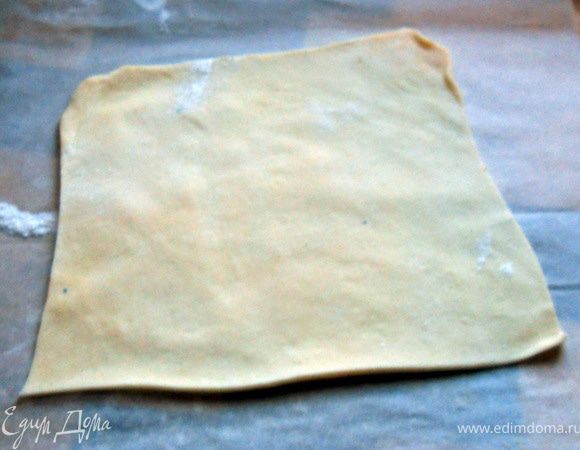 Взять немного теста (остальное пусть находится в холоде), раскатать не очень тонко (просвечивать недолжно), ***удобно делать на пергаменте, присыпанным мукой***. Тесто мягкое липкое, но послушное, главное не переусердствуте с мукой, достаточно присыпать поверхность и скалку***