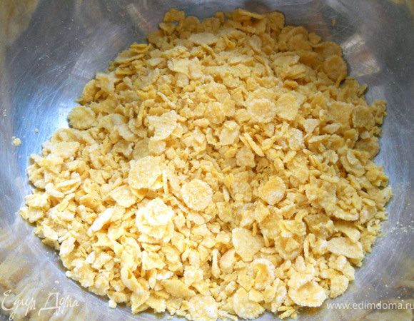 Кукурузные хлопья слегка измельчить, переложить в глубокую миску. 