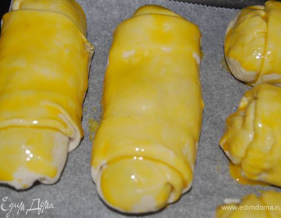 Выложить пирожки на противень с пергаментом, смазать желтком и выпекать 20 минут в разогретой до 200 градусов духовке.