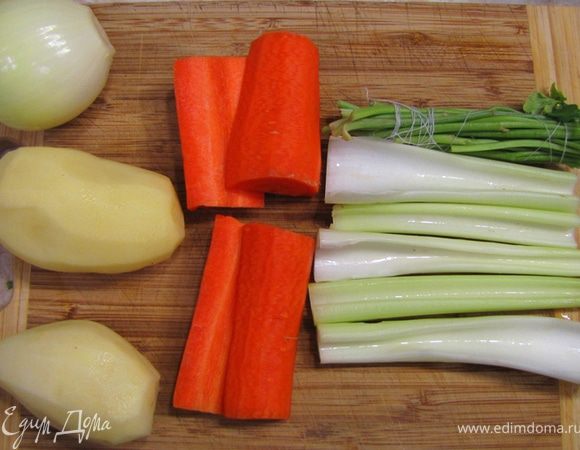 Приготовьте для начала овощной бульон. Для этого нарежьте крупно морковь и сельдерей (на 4 части). Почистите картофель. Почистите луковицу и воткните в нее гвоздику.