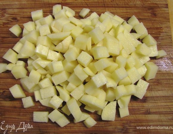 Поставьте снова кастрюлю на маленький огонь. Уберите все инородные включения из пшена. Промойте пшено в проточной воде. Почистите картофель и нарежьте его кубиками со стороной не более 1 см.