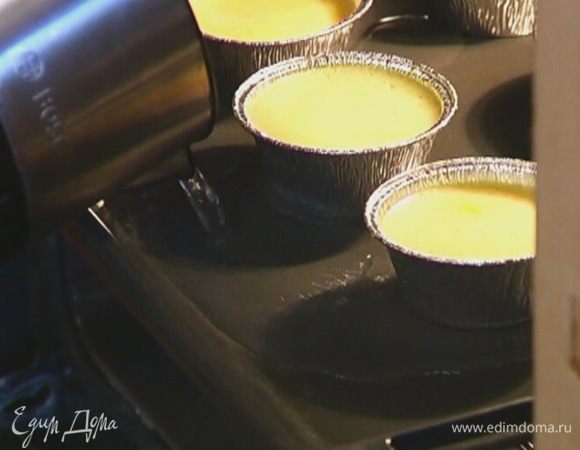 Противень поставить в разогретую духовку, задвинув не до конца, влить в него горячую воду на 1/3 высоты формочек.
