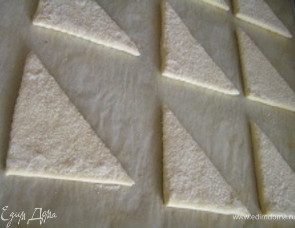 Каждый треугольник опустить с одной стороны в сахар, слекга придавить, выложить на противень (сахарной стороной вверх)