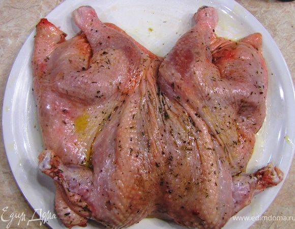 Теперь продевайте пальцы со стороны шеи между кожей и мясом. Осторожно, чтобы не порвать кожу отделяйте кожу так, чтобы потом можно было туда засунуть начинку. При этом помните где кожа сильно прикреплена (см. выше). Не забудьте отделить кожу и на ножках вплоть до самой голени. У вас получится "кожанный мешочек" прикрепленный к тушке по позвоночнику (с двух сторон от распластанной курицы), на крылышках, по грудной кости и на концах ног.
Смешайте сухие пряности, добавьте щепотку соли и столько же свежемолотого черного перца. Оботрите сухой смесью курицу со всех сторон.
Полейте курицу оливковым маслом с обеих сторон и вотрите масо в курицу. Поставьте курицу мариноваться около часа.