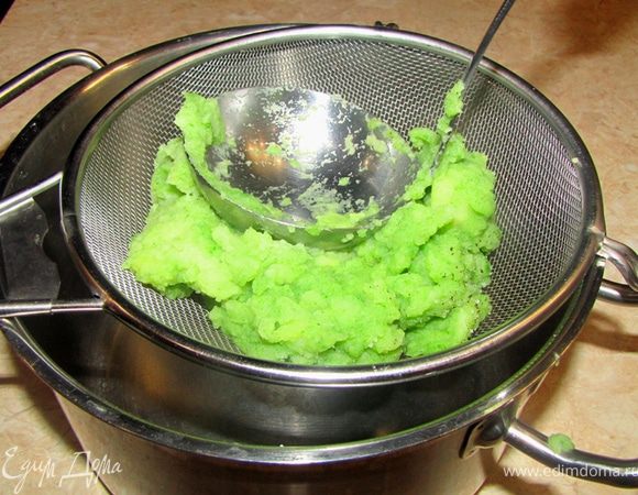 Размешайте, попробуйте и досолите, если надо.
Возьмите вторую кастрюлю.
Через сеточный дуршлаг с помощью половника, как показано на фотографии протрите вращательными движениями половника пюре частями через сито.
Долейте отвара, если вам покажется, что пюре получилось слишком густым.