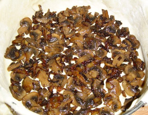 Готовое слоеное тесто раскатываем и укладываем в ,предварительно смазанную маслом, разъемную форму. На тесто выкладываем грибы с луком,