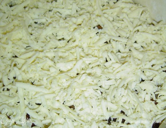 Последним ингредиентом будет брынза. Натираем ее на терке и засыпаем баклажаны.