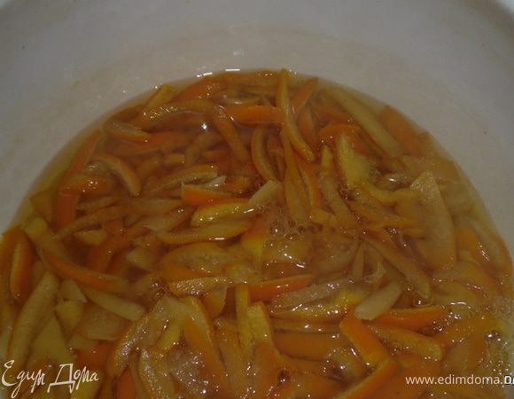 В кастрюлю всыпать 2 стакана сахара, залить 1 стакан кипятка, дать закипеть. Опустить в этот сироп нарезанную кожуру. 

Варить на среднем огне до почти полного уваривания(примерно от 25-35 мин)

Можно ложкой помешивать или периодически встряхивать кастрюлю. 
