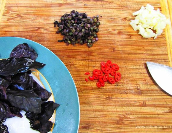 Промойте помидоры и порежьте их на части. Маленькие помидоры достаточно разрезать пополам.
Ударьте плоской частью ножа по зубчику чеснока, чтобы кожица лопнула. Срежьте попку и сделайте тоже самое со всеми зубчиками.
Порубите чеснок довольно крупно.
С веточек базилика сорвите листочки. Порубите стебли и отдельно порубите листья.
Порубите мелко жгучий перец.