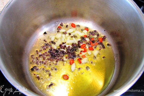Разогрейте масло в сотейнике или неглубокой кастрюле на среднем огне. Положите туда чеснок, веточки базилика и жгучий перец.