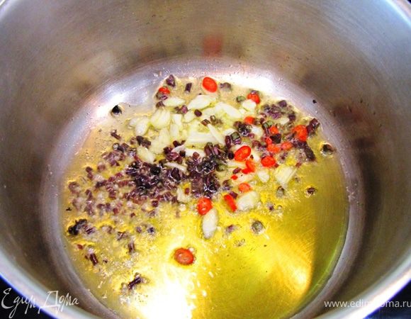 Разогрейте масло в сотейнике или неглубокой кастрюле на среднем огне.
Положите туда чеснок, веточки базилика и жгучий перец.