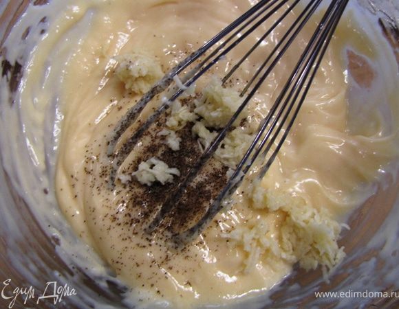 Положите чеснок и черный перец в майонез. Хорошо перемешайте.
Добавьте ложку воды и снова перемешайте. Если у вас получился очень густой майонез, то возможно, что вам придется добавить пару столовых ложек.