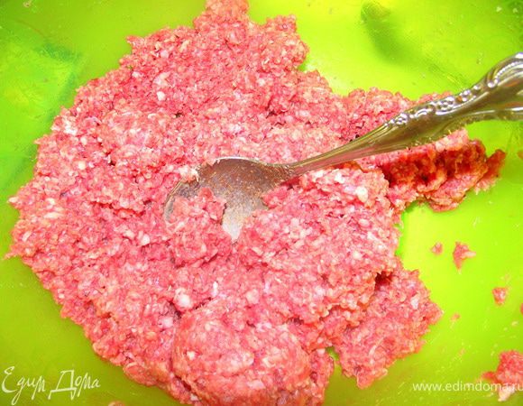 В фарш добавить воду, яйцо и специи. Перемешать.