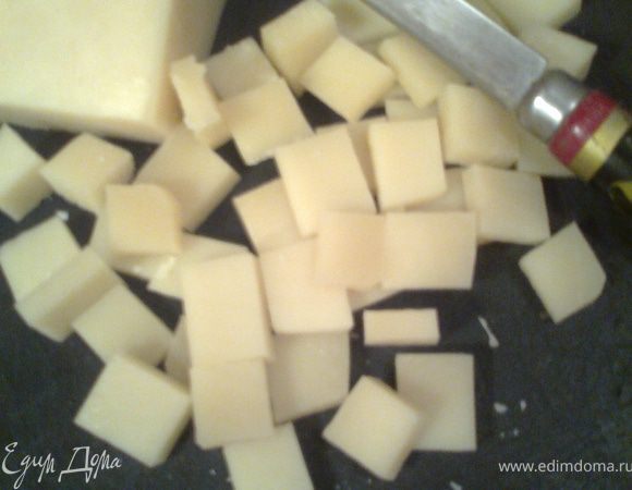 Нарезаем сыр кубиками,чтобы влезли по размеру в отверстия решётки(они провалятся при раскатывании теста)