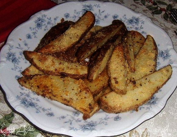 Нагреть духовку до 210/220гр. Накройте противень фольгой и смажьте фольгу жиром.Нарезать картошкув длину на ломтики.Растопить слив.масло на плите или в СВЧ.В большой миске перемешать растопленное слив. масло, растит.масло, чеснок, базилик,орегано,соль и перец. Положить в миску картофель и хорошенько его перемешайте. Разложить картофель на противне. Посыпать пармезаном.Печь картофель минут 30 или до тех пор пока не станет мягким и золотистым.Пару раз во время запекания и перемешайте картофель, чтобы пекся ровно.