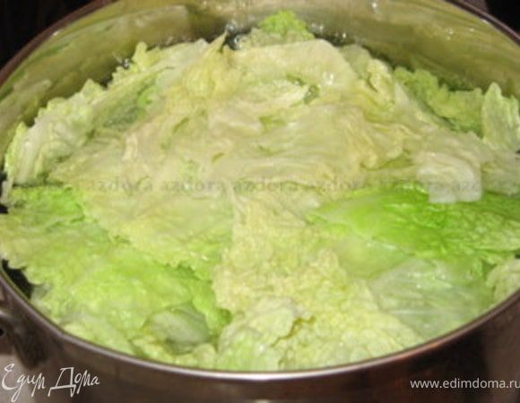У листов савойской капусты вырезать центральную прожилку и опустить в кипящую воду на 3 минуты. Откинуть на дуршлаг. Оставить один половник воды от капусты.
