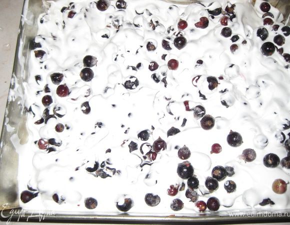 Вынимаем из духовки основу, несколько минут охлаждаем. Выкладываем сверху взбитые белки и, важно!! замороженую смородину, прямо из морозилки, немного лопаткой перемешиваем белки со смородиной. Важно что-бы смородина была замороженая, иначе она сразу пустит сок и белки в духовке осядут.