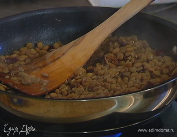 Вынуть из готовой чечевицы лавровые листья, выложить ее в сковороду, перемешать с луком.
